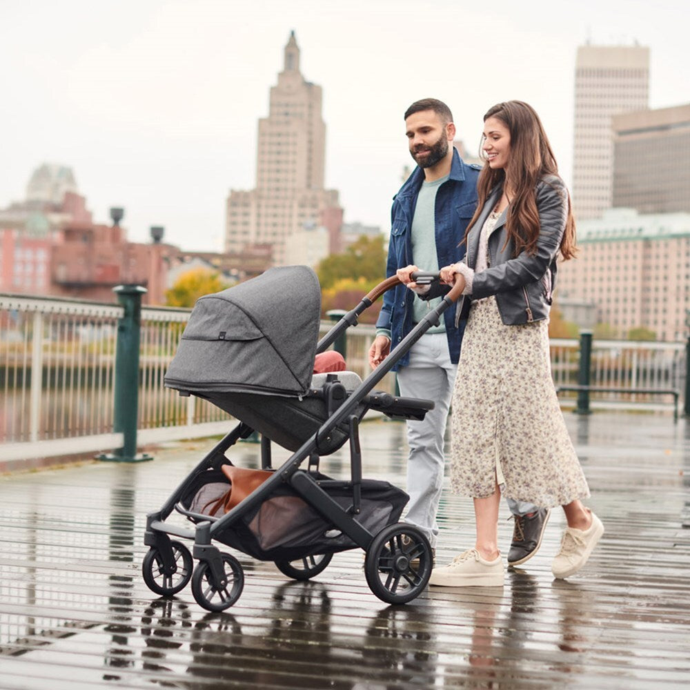 Two parents pushing a baby in a Vista stroller