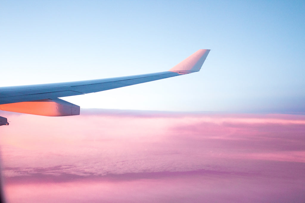 wing of an aeroplane in the sky with pink clouds