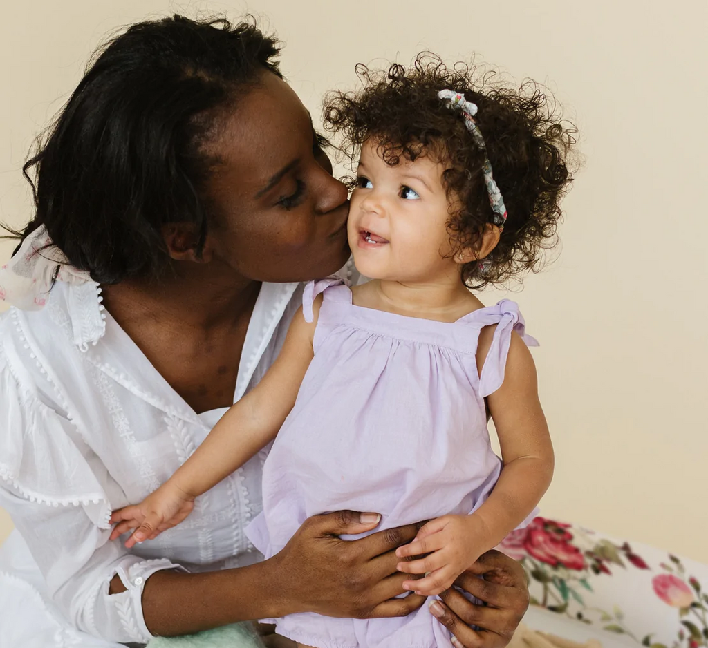 parent embracing and kissing toddler on the cheek